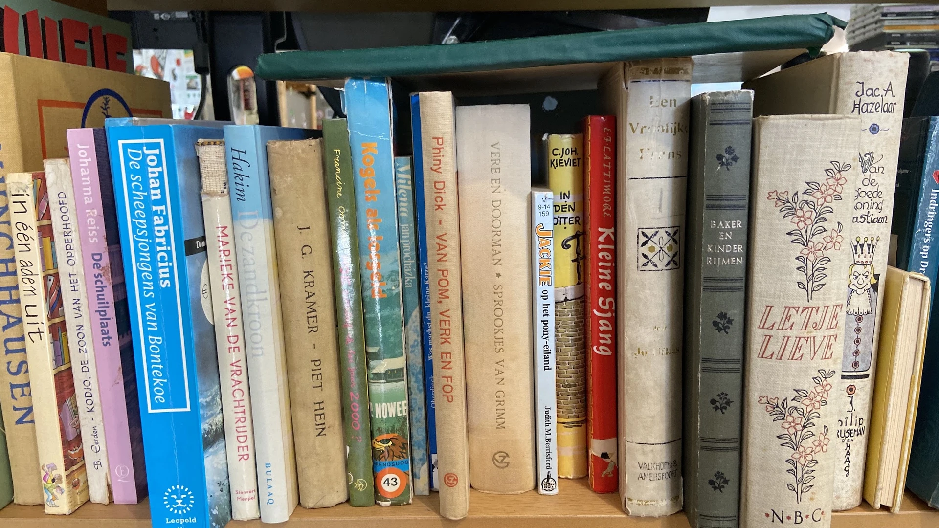 Boekenplank met diverse tweedehands boeken rechtop gerangschikt