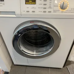 Witte wasmachine met geopende deur, vooraanzicht van dichtbij
