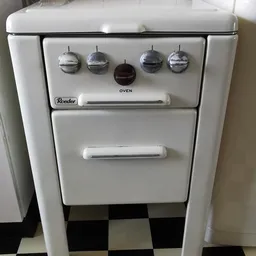 Vintage witte Roeder-fornuis met vier draaiknoppen en twee ovens