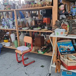 Winkelinterieur met houten stellingen vol diverse tweedehandsartikelen, spullen en decoraties