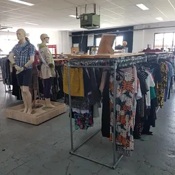 Rekken met tweedehands kleding en mannequins in kringloopwinkel