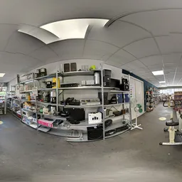 Winkelvloer met stellingen vol spullen, overkapt plafond met vierkante panelen en natuurlijk licht