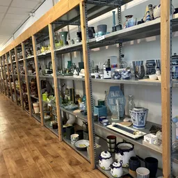 Glazen vitrinekasten met huishoudelijke items, decoratie en serviesgoed netjes uitgestald