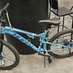 Blauwe kinderfiets met zwarte band en zwarte zadeltas tegen donkere achtergrond