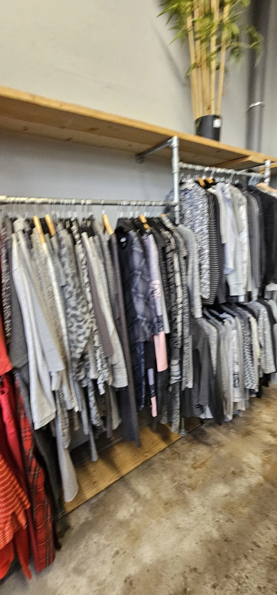 Rekken met tweedehands kleding in verschillende kleuren en patronen