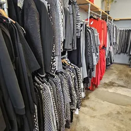 Rekken met tweedehands dameskleding in verschillende kleuren en patronen