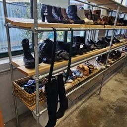 Stellingen met uitgestalde tweedehands schoenen en laarzen in verschillende kleuren en stijlen