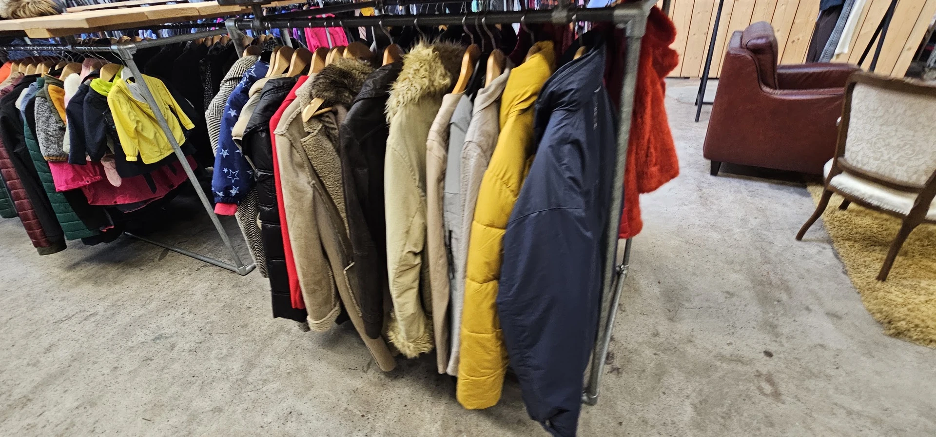 Rekken met tweedehands jassen en jacks in verschillende kleuren