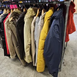 Rekken met tweedehands jassen en jacks in verschillende kleuren