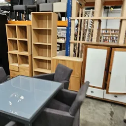Winkelvloer met houten kasten, tafels en stoelen in een kringloopwinkel