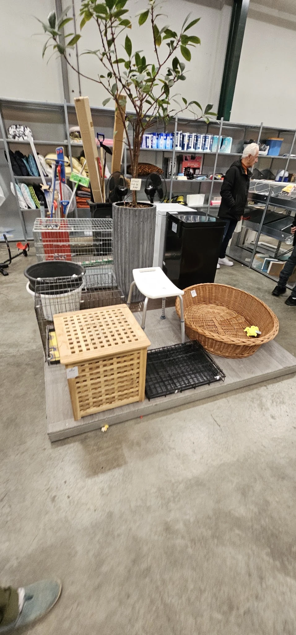 Diverse tweedehands meubels en huishoudartikelen: houten laundry basket, witte stoel, rieten mand, zwarte gootsteen en andere