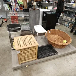 Diverse tweedehands meubels en huishoudartikelen: houten laundry basket, witte stoel, rieten mand, zwarte gootsteen en andere