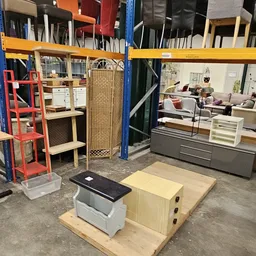 Winkelvloer met uitgestalde meubels, kasten en decoratieve items in een kringloopwinkel