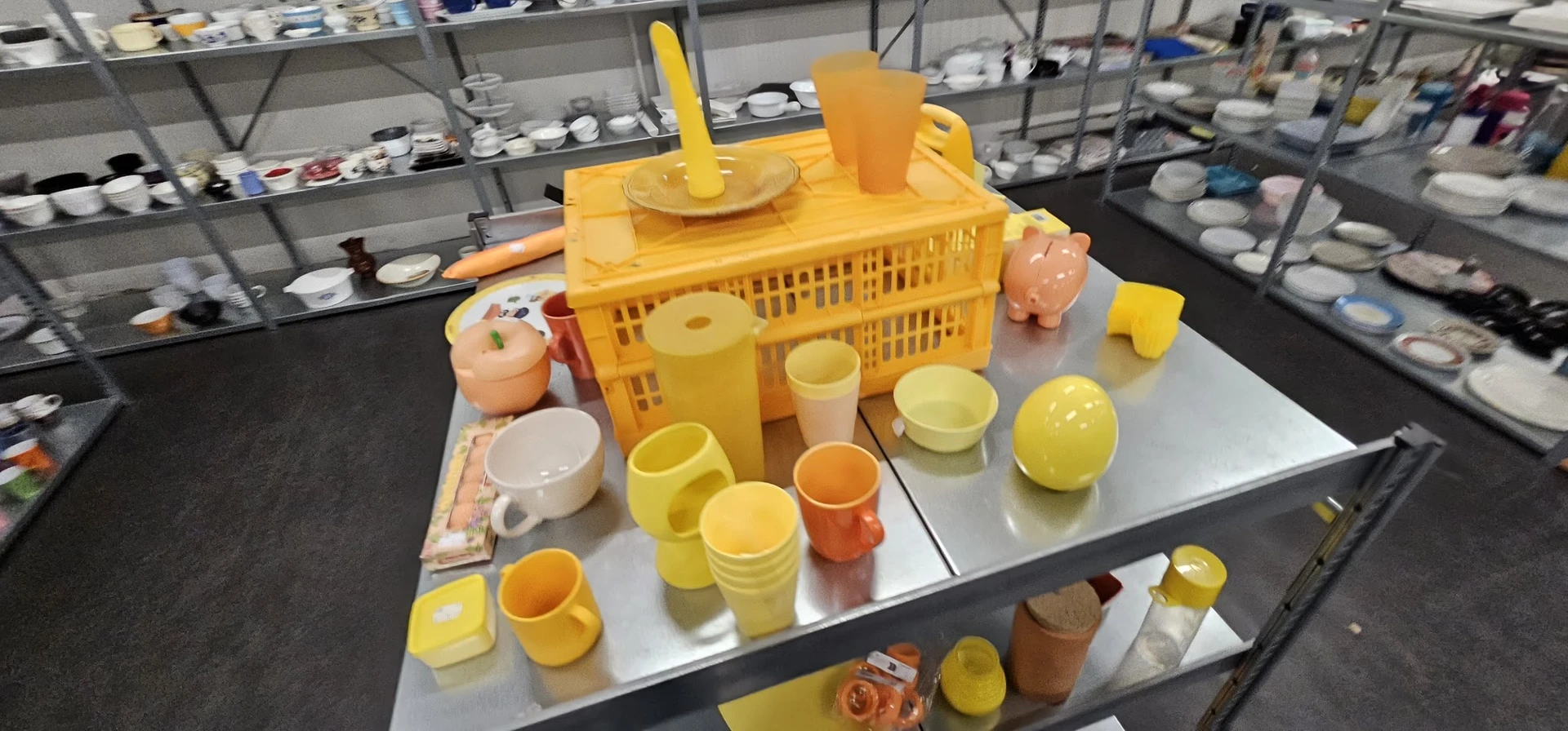 Gele kunststof huishoudartikelen en servies uitgestald op tafel in de winkel