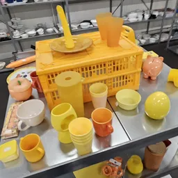 Gele kunststof huishoudartikelen en servies uitgestald op tafel in de winkel