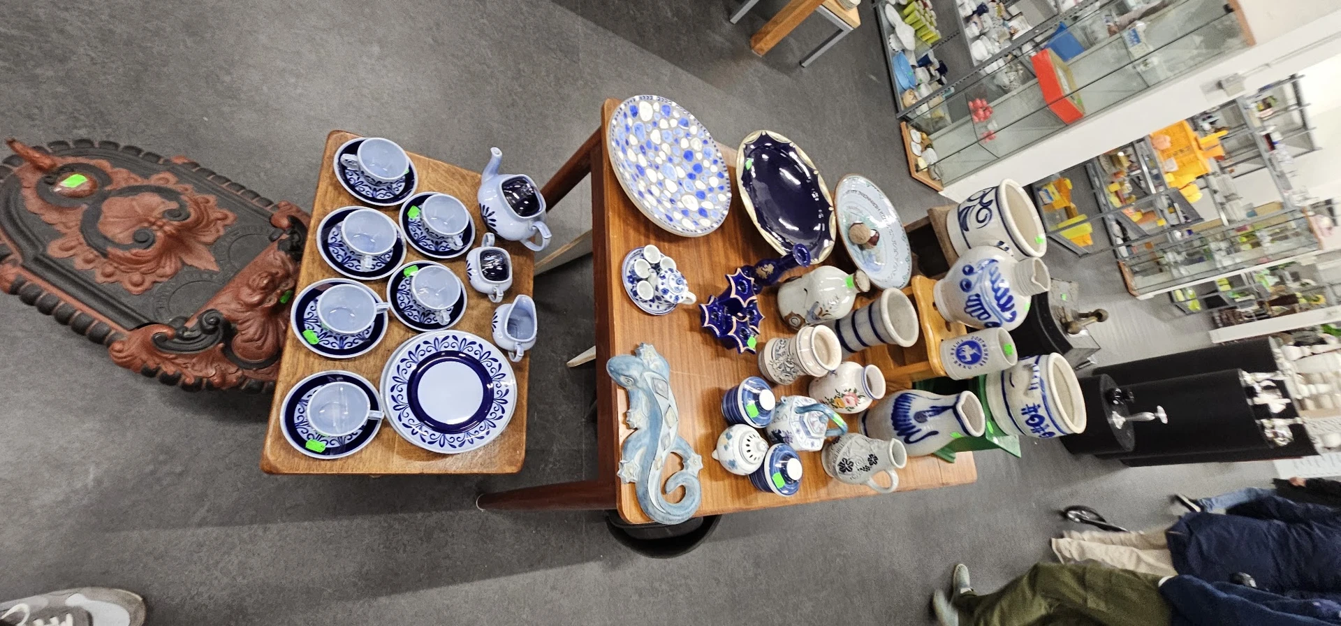 Tweedehands servies en tafelgerei met blauwe decoratie uitgestald op houten tafels