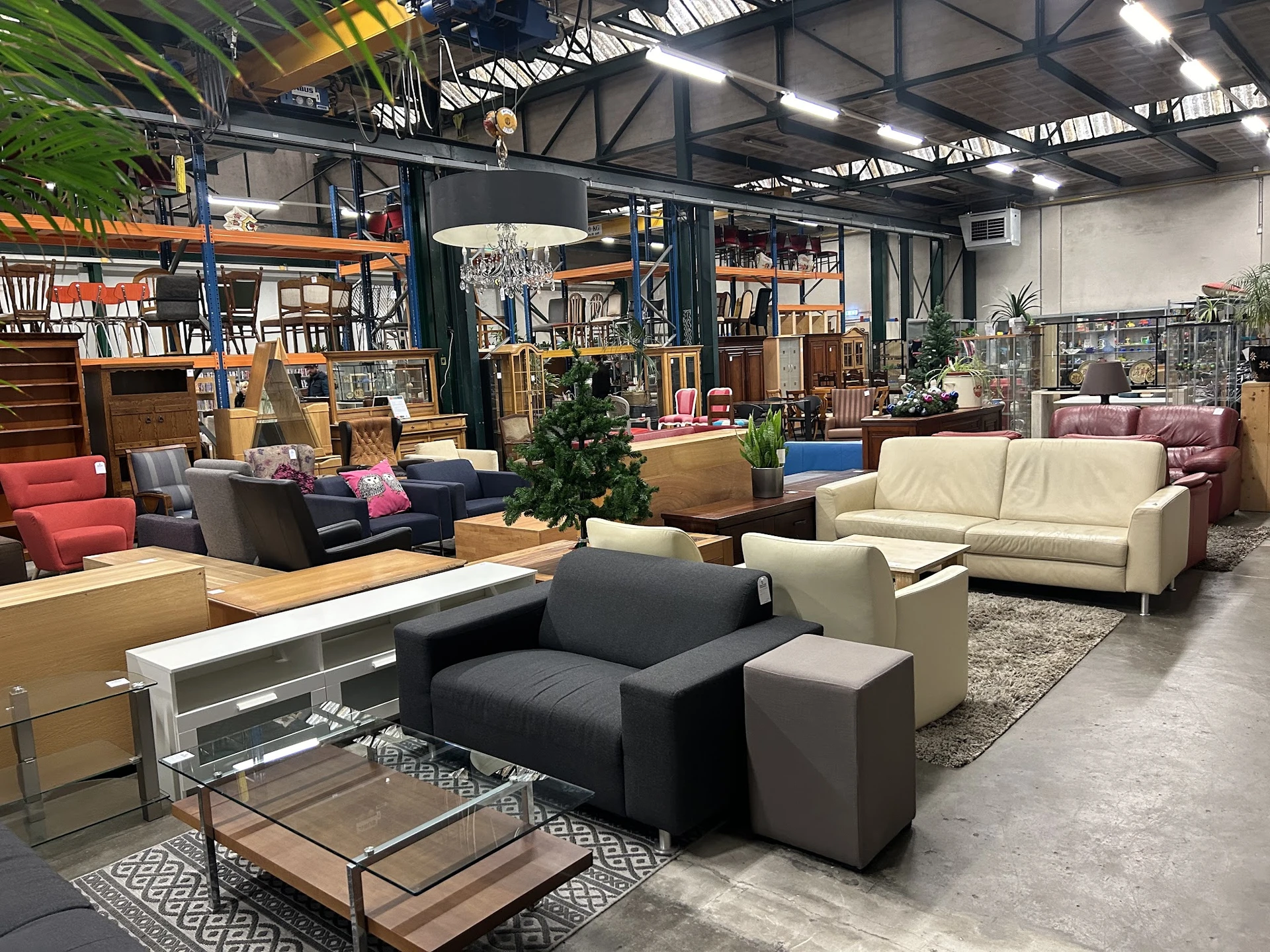 Ruim winkelinterieur met diverse zitmeubels, kasten en inrichtingsobjecten, breed overzicht van de vloer
