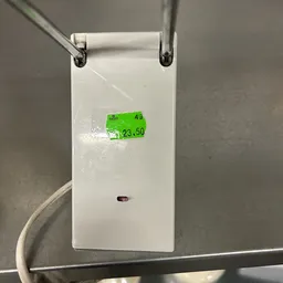 Witte elektrische stekkerdoos met groene prijssticker (€23,50)