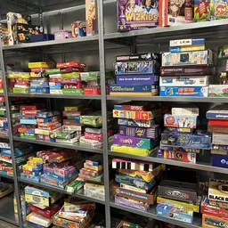 Stellingen vol met tweedehands bordspellen en spellen in gekleurde dozen