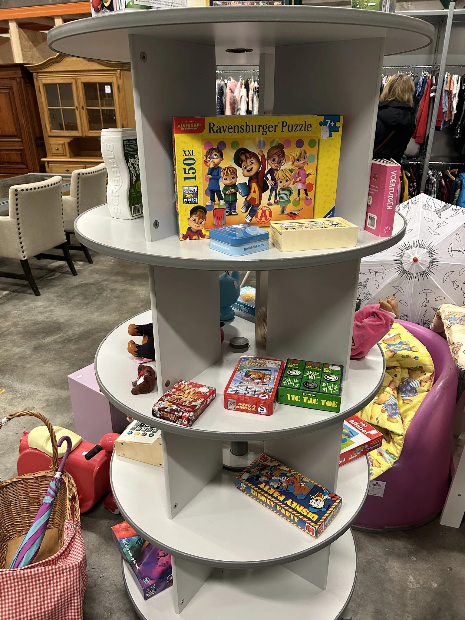 Ronde kast met meerdere niveaus vol speelgoed, bordspellen en kinderartikelentop winkelvloer
