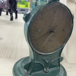 Close-up van een vintage groene schaalweegschaal met ronde wijzerplaat en nummeraanduiding