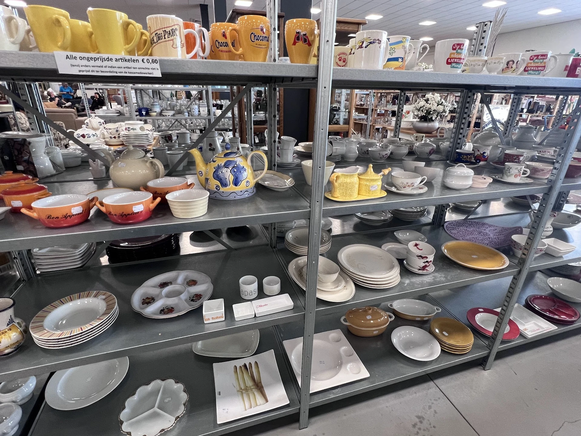 Vitrinekasten met serviesgoed, borden, kopjes, kannen en ander huishoudelijk aardewerk uit verschillende periodes