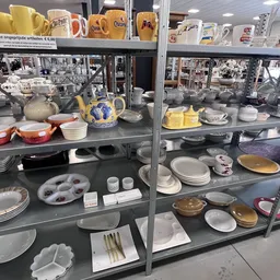 Vitrinekasten met serviesgoed, borden, kopjes, kannen en ander huishoudelijk aardewerk uit verschillende periodes