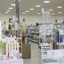 Winkelinterieur met diverse uitgestalde spullen op stellingen, toonbanken en in vitrinekasten