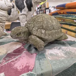 Stenen decoratief beeldje van een schildpad op een gekleurde ondergrond