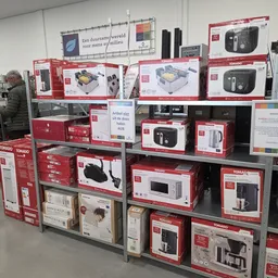 Stellingen vol met verpakte huishoudelijke apparaten en elektronische items in rode doosjes