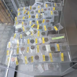 Collectie munten en numismatische items in plastic houders met gele etiketten