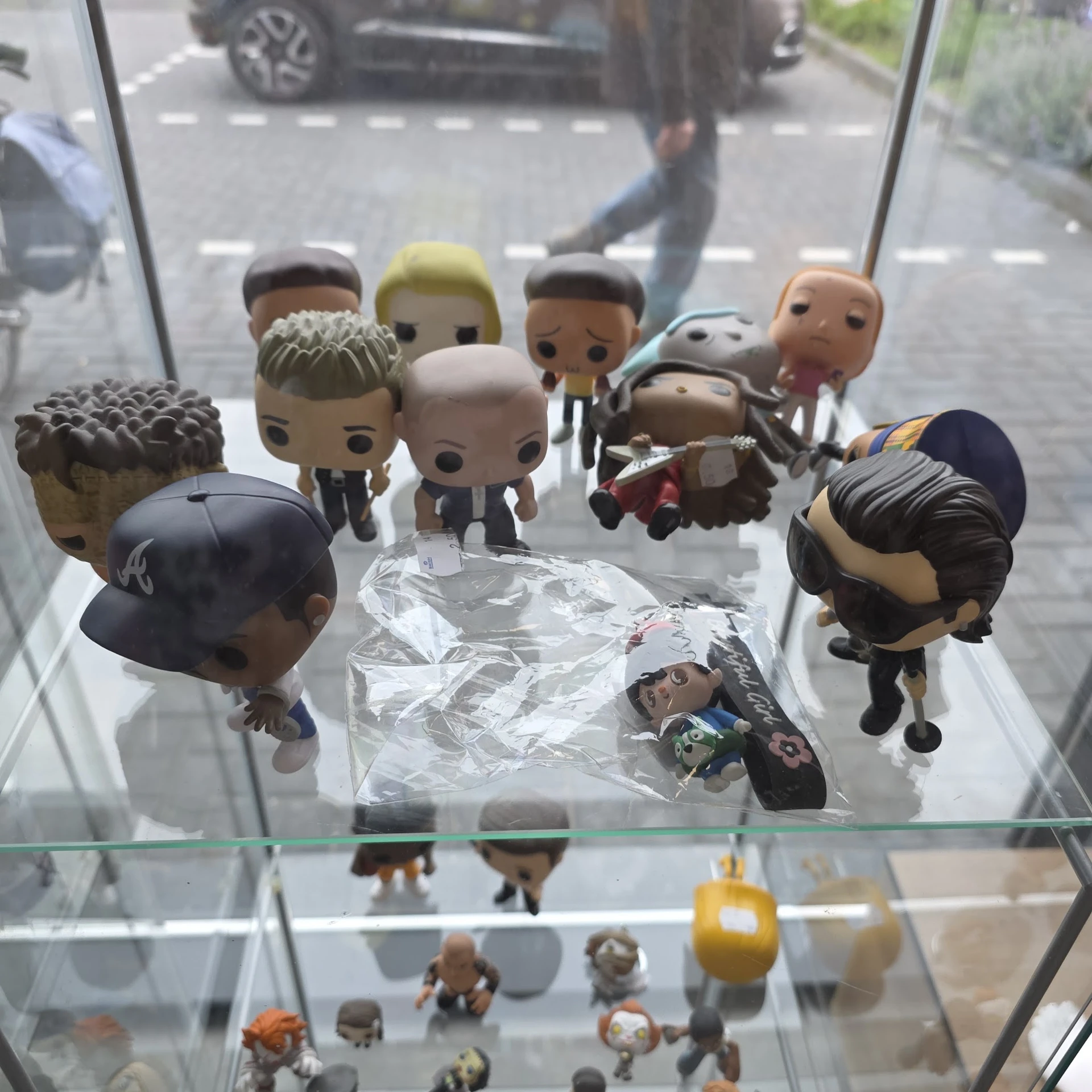 Verzameling Funko Pop-figuren op glazen plank, waaronder personages in verschillende outfits en poses