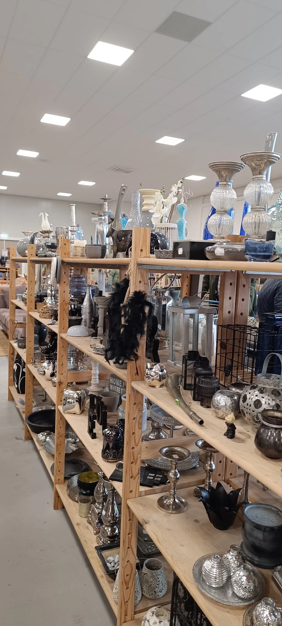 Houten stellingen met diverse huishoudelijke artikelen, decoratie en glazen items