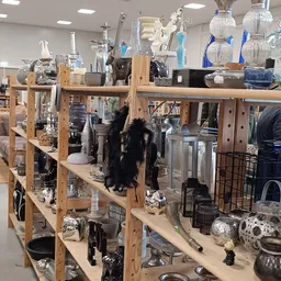 Houten stellingen met diverse huishoudelijke artikelen, decoratie en glazen items