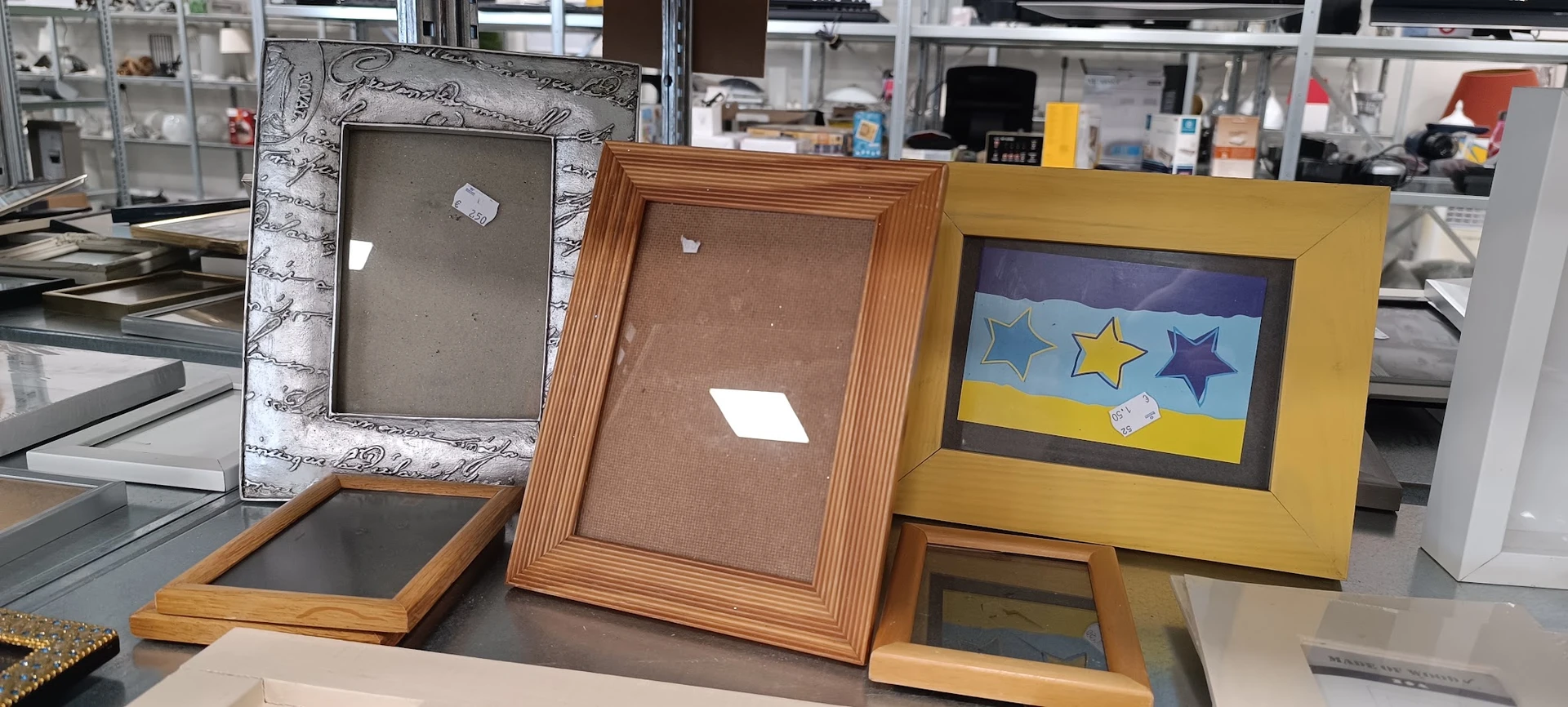 Verschillende houten fotolijsten met bruine en gekleurde mats op een tafel