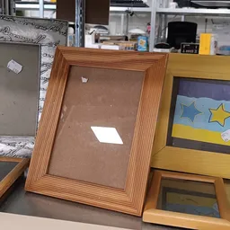 Verschillende houten fotolijsten met bruine en gekleurde mats op een tafel