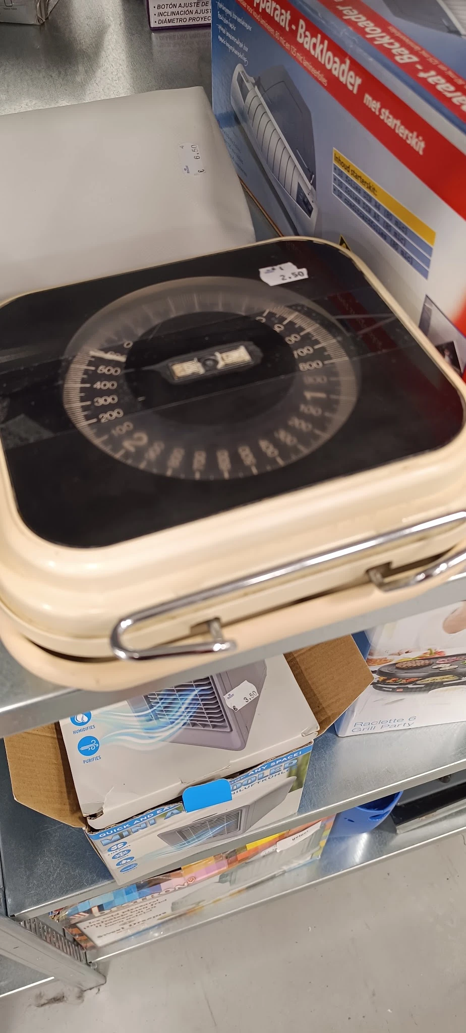 Close-up van een vintage weegschaal met zwarte wijzerplaat en crèmekleurige behuizing