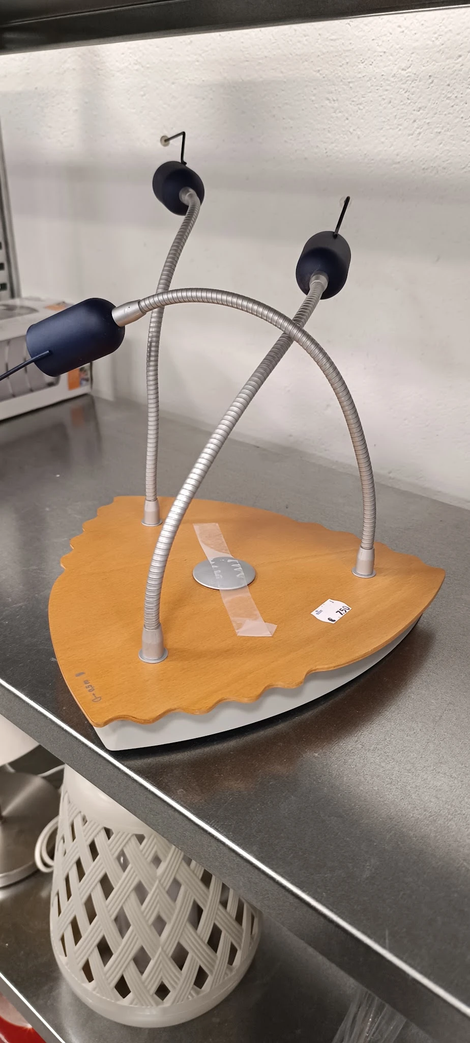 Houten schaakbord met twee metalen gooseneck-lampen erop, op een werkblad