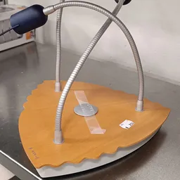 Houten schaakbord met twee metalen gooseneck-lampen erop, op een werkblad
