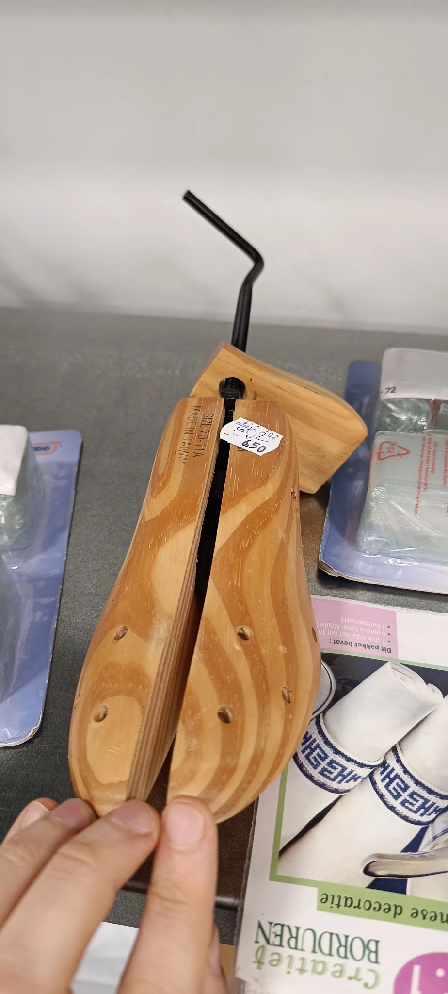 Close-up van een houten schoenlepel met zwarte metalen schacht en prijskaartje