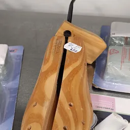 Close-up van een houten schoenlepel met zwarte metalen schacht en prijskaartje