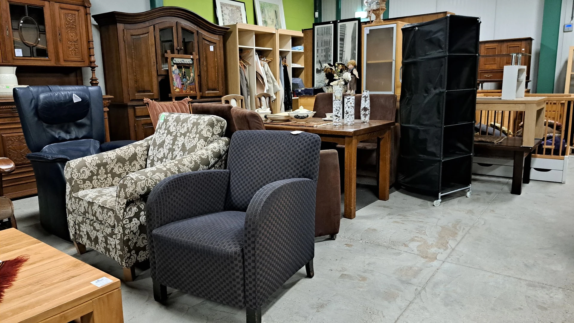 Tweedehands meubels: fauteuils, kasten en tafels in de winkelruimte