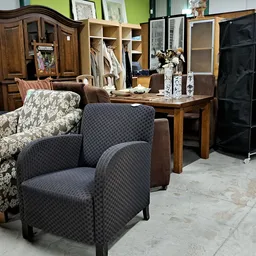 Tweedehands meubels: fauteuils, kasten en tafels in de winkelruimte