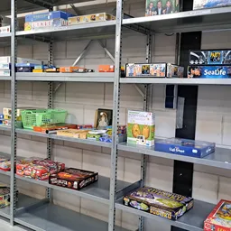 Metalen stellingen met diverse tweedehands artikelen zoals bordspellen, boeken en huishoudartikelen