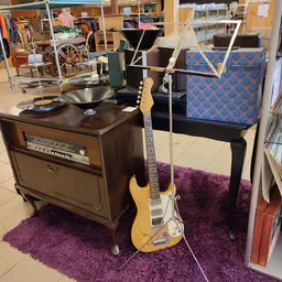 Elektrische gitaar, versterker en vintage radio's uitgestald in kringloopwinkel