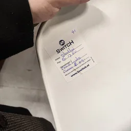 Prijssticker van Switch op een wit voorwerp met handgeschreven aantekeningen