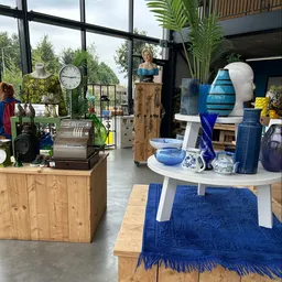 Winkelvloer met uitgestalde huishoudartikelen, decoratie en meubels in een moderne kringloopwinkel