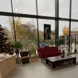 Moderne winkelinterieur met grote ramen, rode fluweelsofa, grijze stoelen en huisplanten