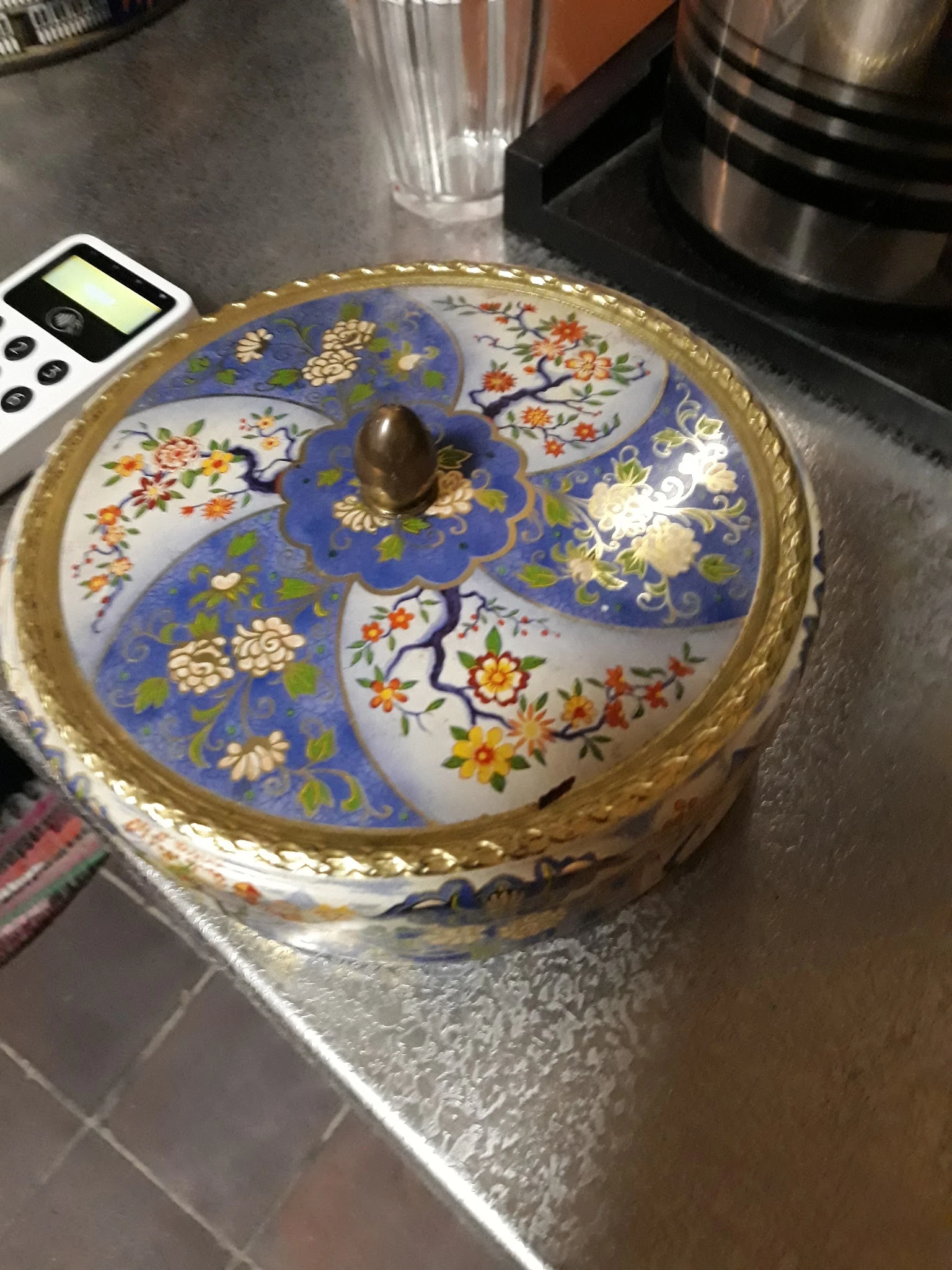 Decoratieve porseleinen doos met blauw glazuur en bloemmotieven, goudkleurige rand en bronzen knop