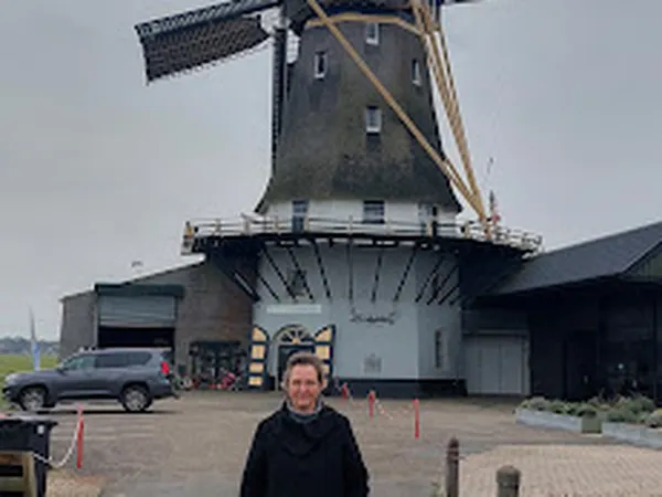 Voorkant van Molenwinkel Adullam met Nederlandse windmolen op het dak, parkeerplaats en ingang zichtbaar